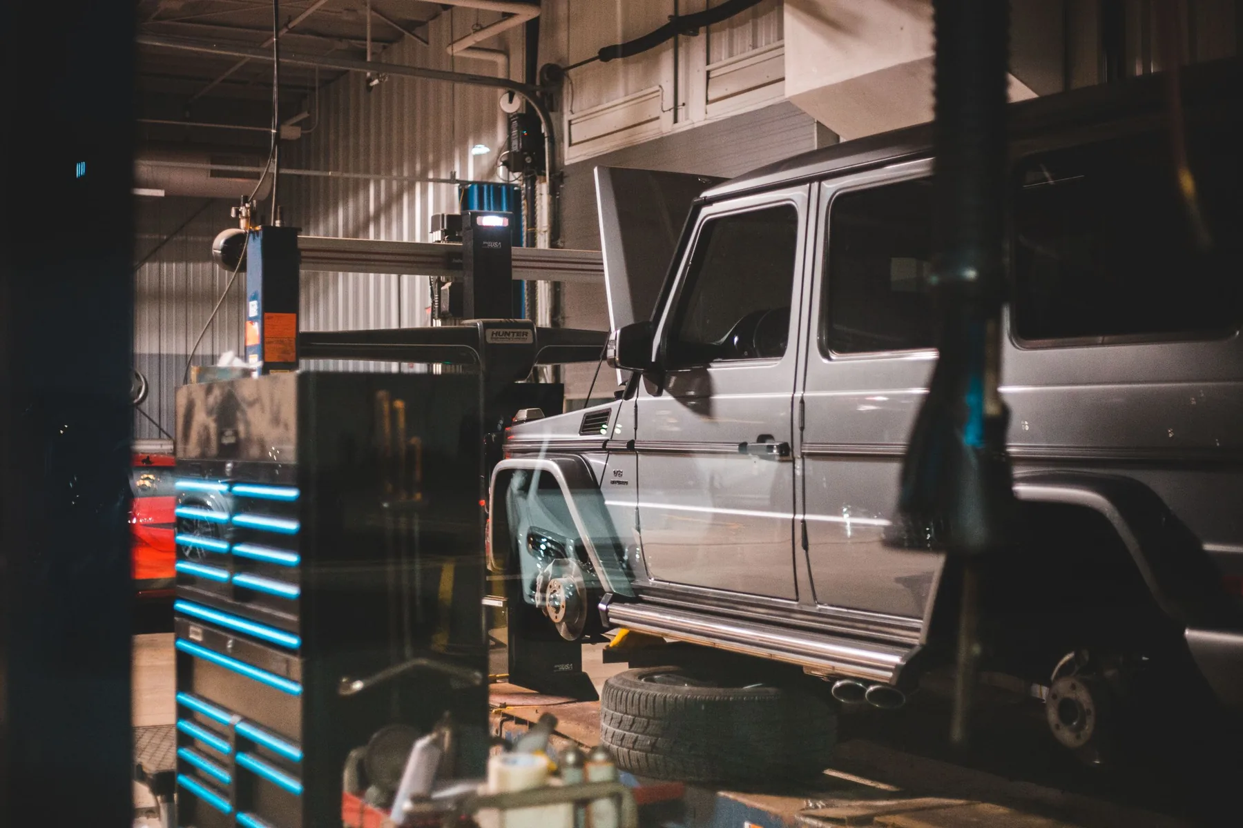 A car in for repair inside the workshop, tools and equipment around it