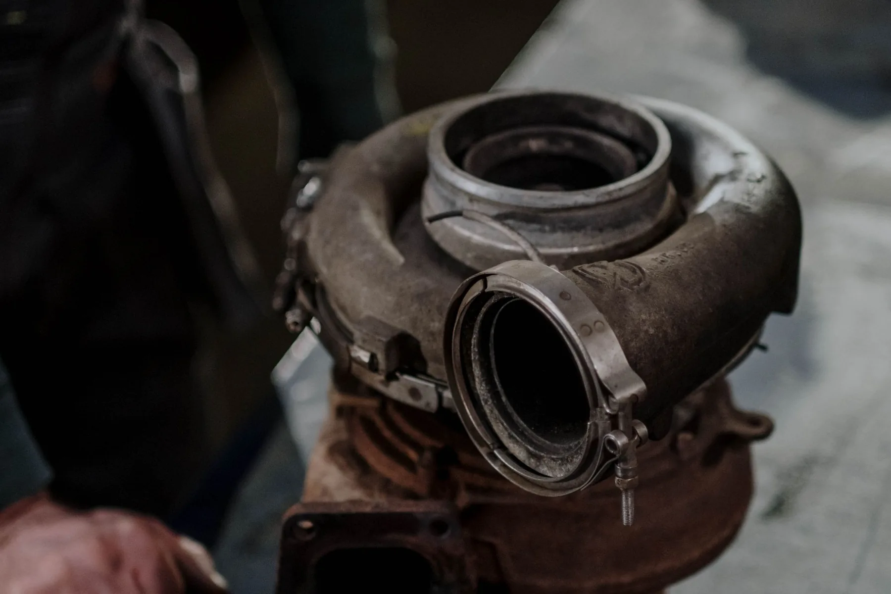 A sooted-up turbocharger off a diesel engine, on the bench